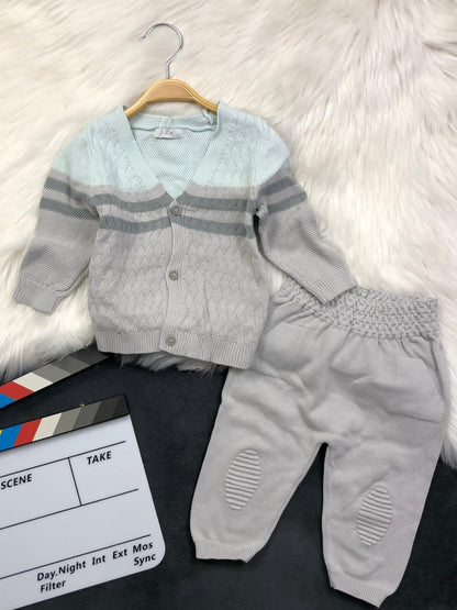The Nile Luxuries infant knit cardigan and trousers set in light blue and grey with textured patterns and buttons.