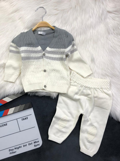 The Nile Luxuries infant knit cardigan and trousers set in cream and grey with textured patterns and button closure.