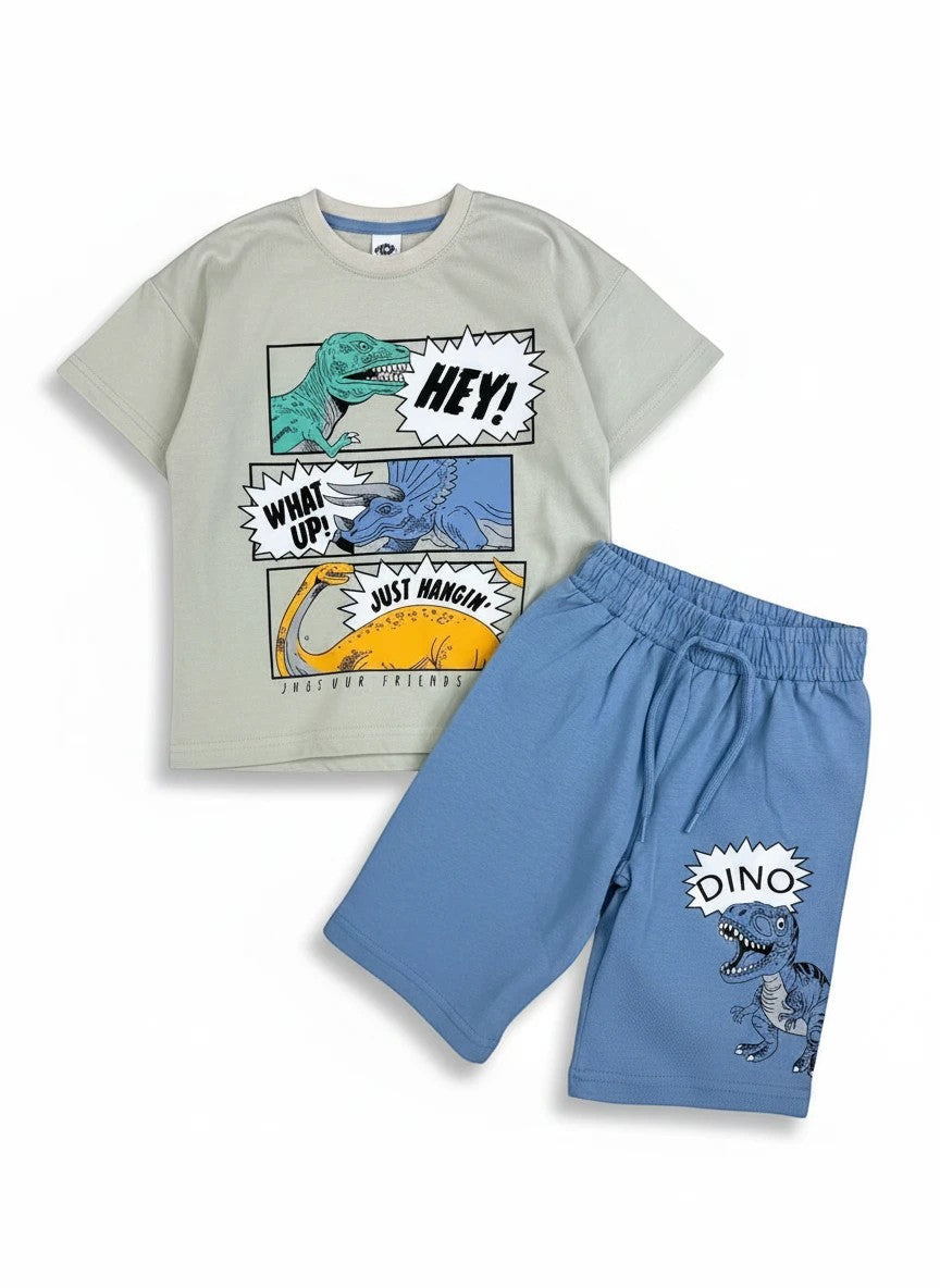 The Nile Luxuries kids light beige t-shirt with dinosaur graphics and blue shorts set. T-shirt has "HEY!", "WHAT UP!", "JUST HANGIN'" text. Shorts have "DINO" graphic.