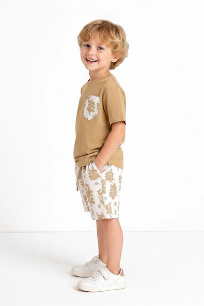 The Nile Luxuries boys' tan t-shirt with leaf print pocket and matching leaf print shorts. Comfortable summer set.
