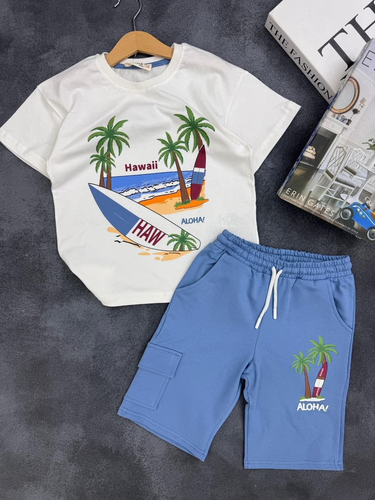 The Nile Luxuries kids summer set with white Hawaii graphic t-shirt and blue cargo shorts with palm tree print.