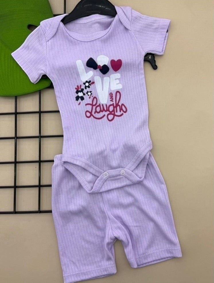 The Nile Luxuries lavender ribbed knit baby bodysuit and shorts set with "LOVE and Laugh" graphic. Short sleeves, snap closure.