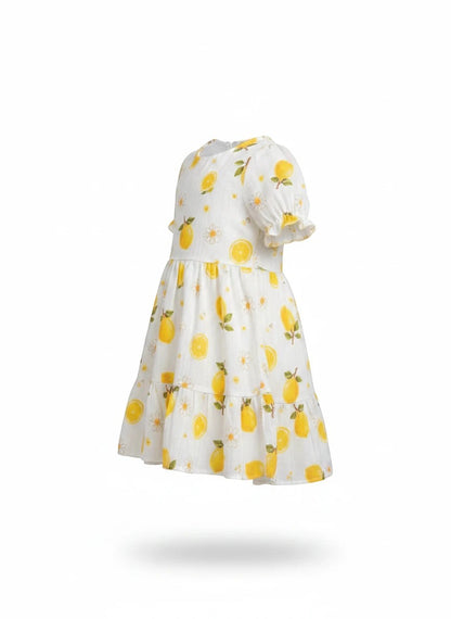 The Nile Luxuries girls white tiered dress featuring a vibrant yellow lemon and daisy print with puff sleeves.