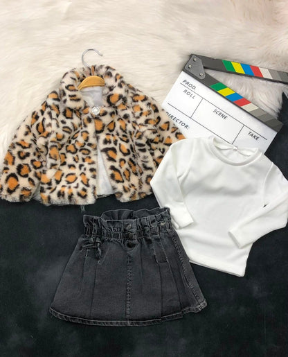 The Nile Luxuries three-piece outfit featuring a leopard print faux fur jacket, white ribbed top, and denim skirt.