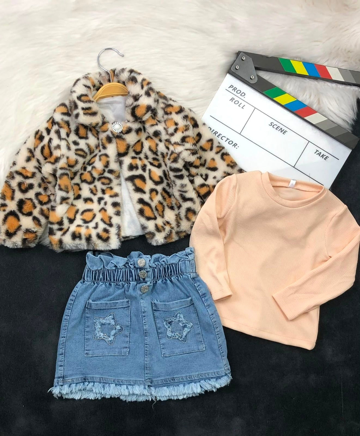 The Nile Luxuries three-piece set with a leopard faux-fur jacket, peach ribbed top, and denim star-pocket skirt.