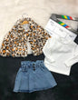 The Nile Luxuries three-piece outfit with leopard print faux fur jacket, white ribbed top, and pleated denim skirt.
