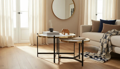 The Nile Luxuries nesting coffee tables with white and grey marble tops and gold trim, on black metal legs.