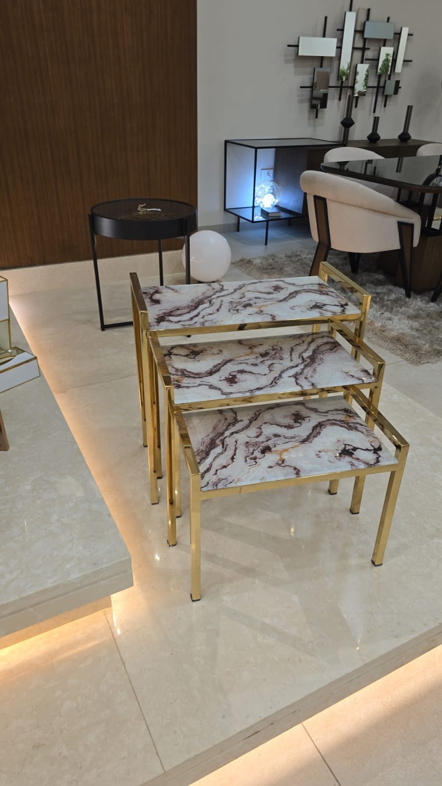 The Nile Luxuries set of 3 nesting tables with white and burgundy marble-effect tops and gold metal frames.