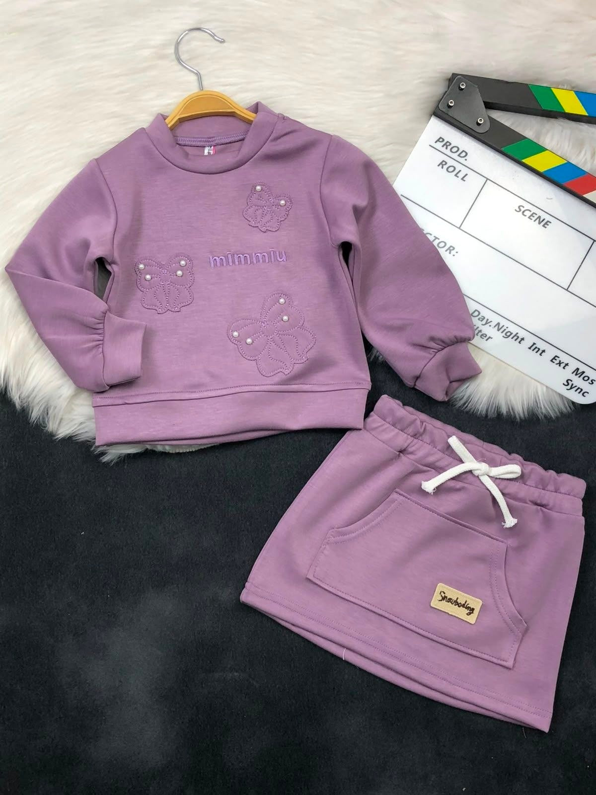 The Nile Luxuries girls mauve sweatshirt and skirt set with butterfly embroidery, pearl accents, and front pocket.