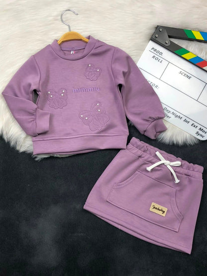 The Nile Luxuries girls mauve sweatshirt and skirt set with butterfly embroidery, pearl accents, and front pocket.