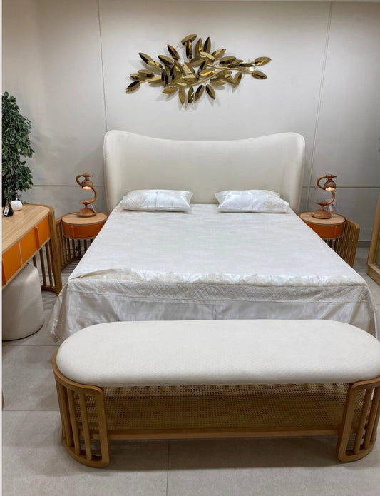 The Nile Luxuries modern bedroom set with upholstered bed, orange vanity, rattan bench, and gold leaf wall art.