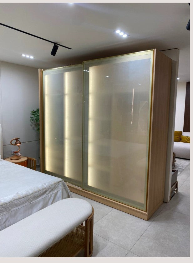 The Nile Luxuries modern bedroom wardrobe with translucent sliding doors and wood frame, illuminated from within.