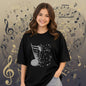 The Nile Luxuries black cotton t-shirt with a glittery musical note graphic that dissolves into smaller notes.