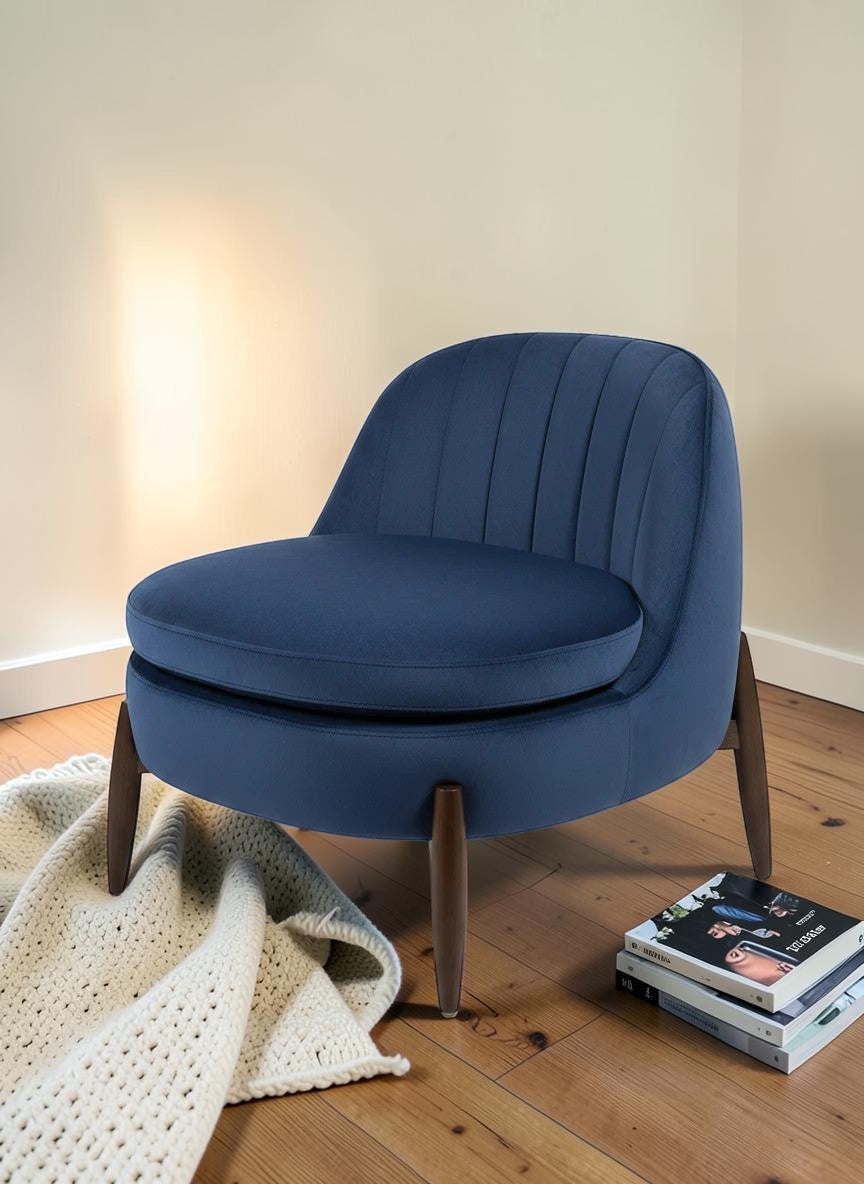 The Nile Luxuries deep navy blue velvet accent armchair with channel tufting and tapered wooden legs.