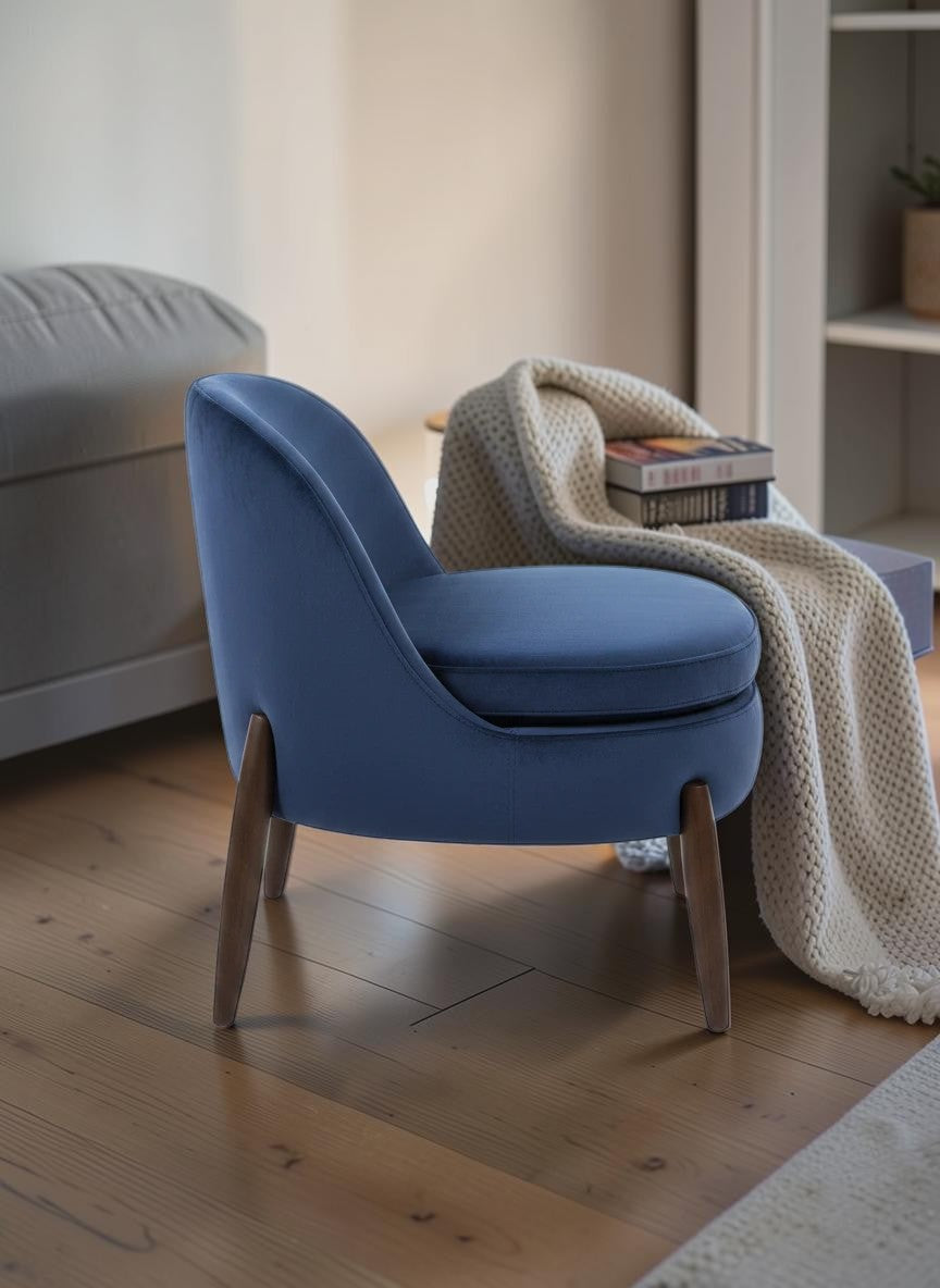 The Nile Luxuries deep navy blue velvet accent armchair with rounded silhouette and tapered wooden legs.