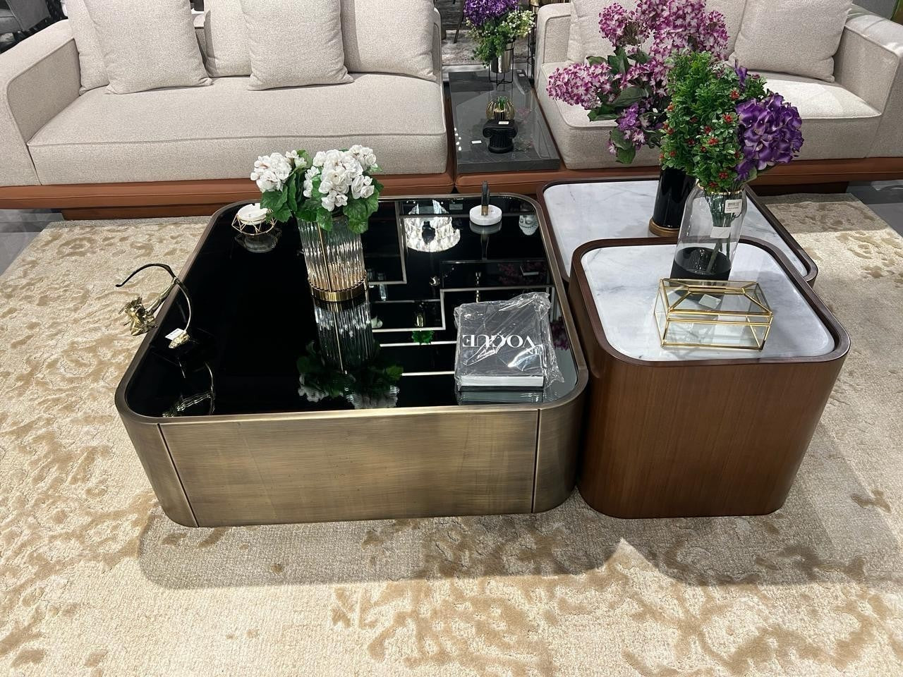 The Nile Luxuries modern nesting coffee table set with black glass and white marble tops, brass and wood veneer bases.