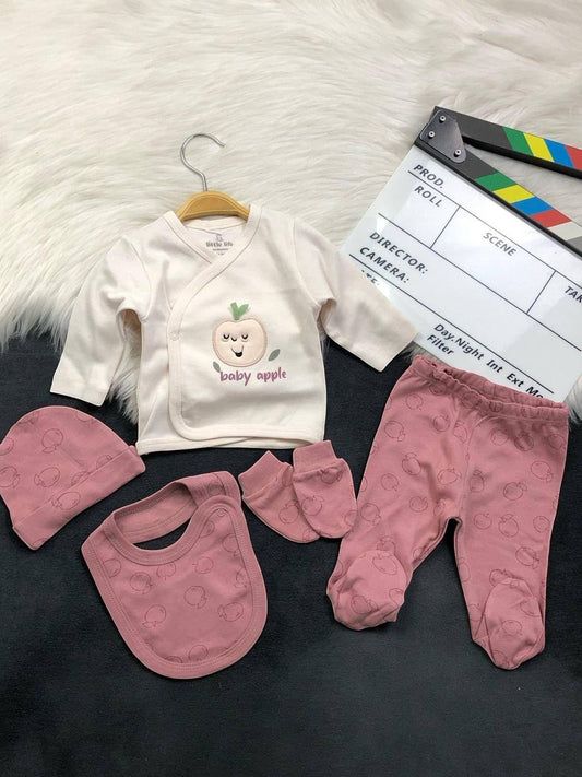 The Nile Luxuries 5-piece newborn cotton layette set with apple print, including wrap top, leggings, bib, and hat.