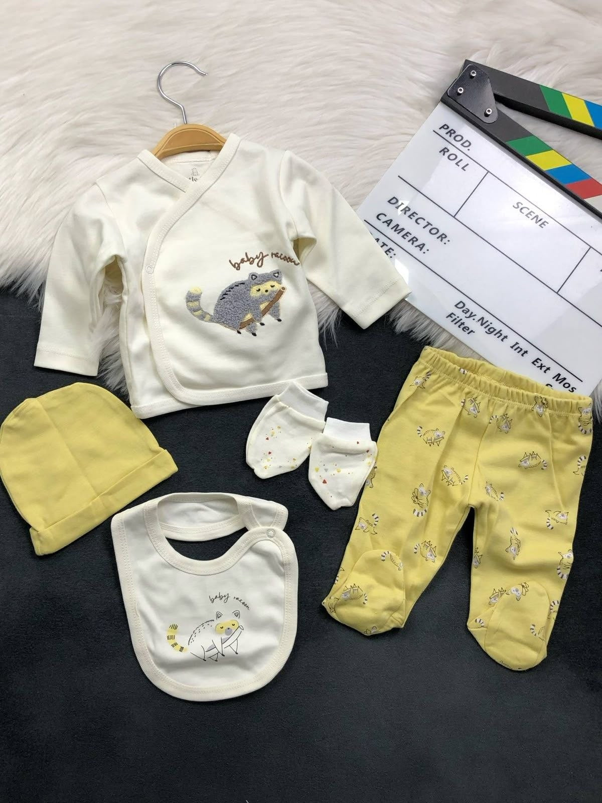 The Nile Luxuries 5-piece newborn set with cream wrap top, yellow footed leggings, beanie, bib, and mittens.