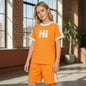 The Nile Luxuries orange casual short sleeve t-shirt and shorts set with white Hi graphic and side stripes on a model.