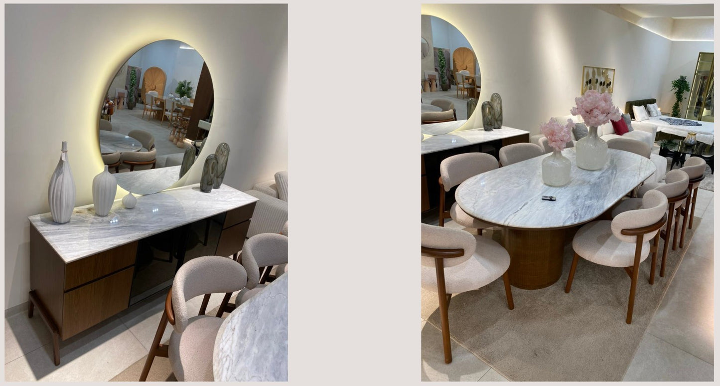 The Nile Luxuries oval marble dining table with dark wood base and upholstered chairs, seats 8. Buffet with marble top and dark wood drawers.
