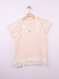 The Nile Luxuries peach cotton t-shirt with metallic leaf print, gold heart emblem, and ruffled hem with fabric roses.