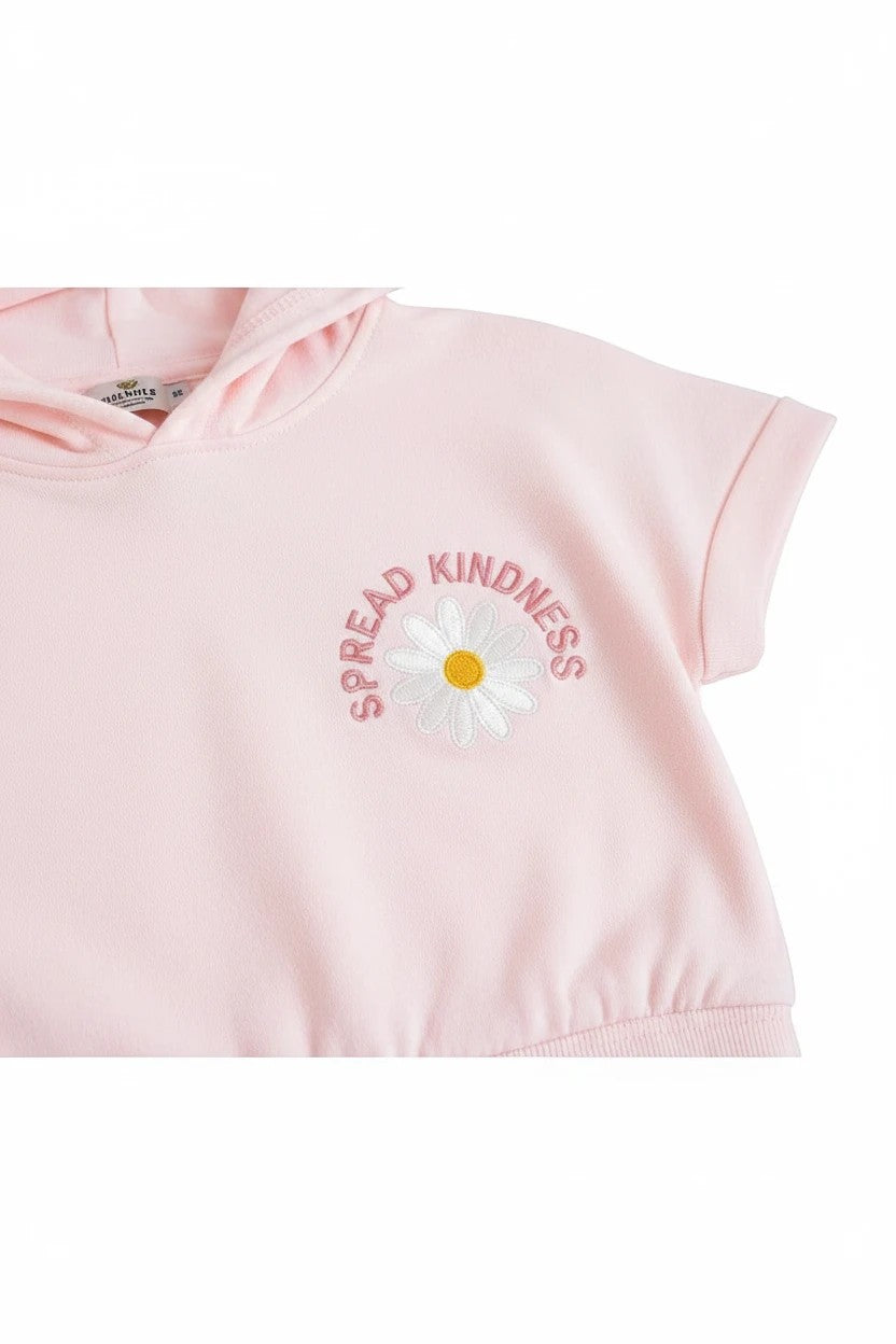 The Nile Luxuries light pink short sleeve cropped hoodie with a white daisy graphic and Spread Kindness text embroidery.