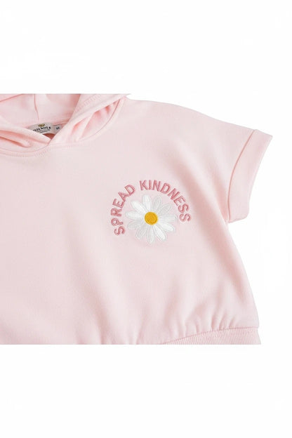 The Nile Luxuries light pink short sleeve cropped hoodie with a white daisy graphic and Spread Kindness text embroidery.