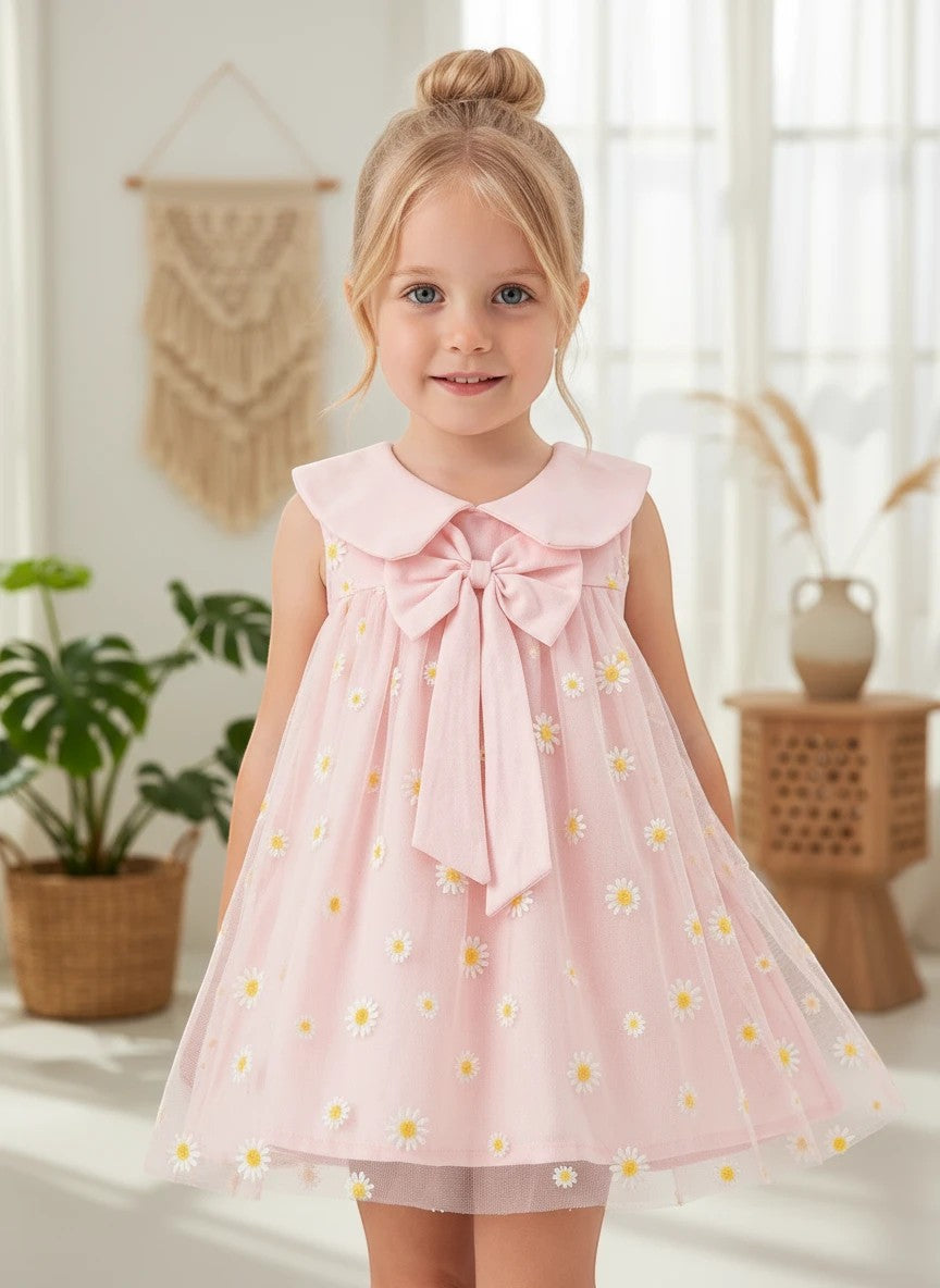 The Nile Luxuries pink tulle dress for girls featuring daisy embroidery, a Peter Pan collar, and a large bow detail.