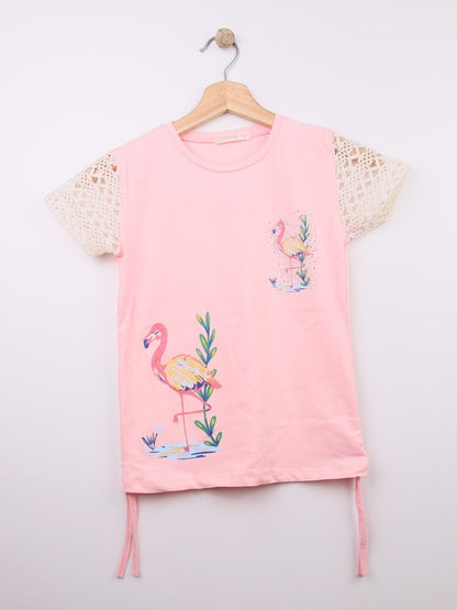 The Nile Luxuries pink cotton t-shirt with flamingo graphic and crochet lace sleeves. Features adjustable side ties.