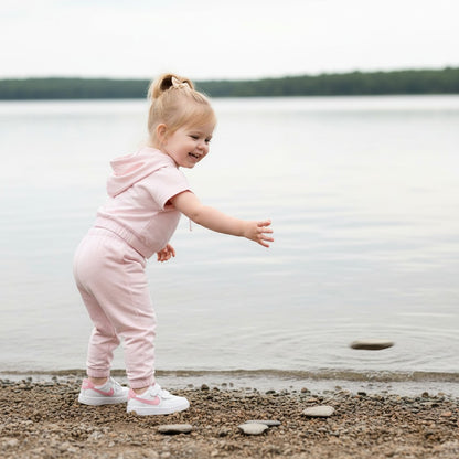 The Nile Luxuries pink cotton blend hoodie and joggers set with daisy graphic and "Spread Kindness" text.