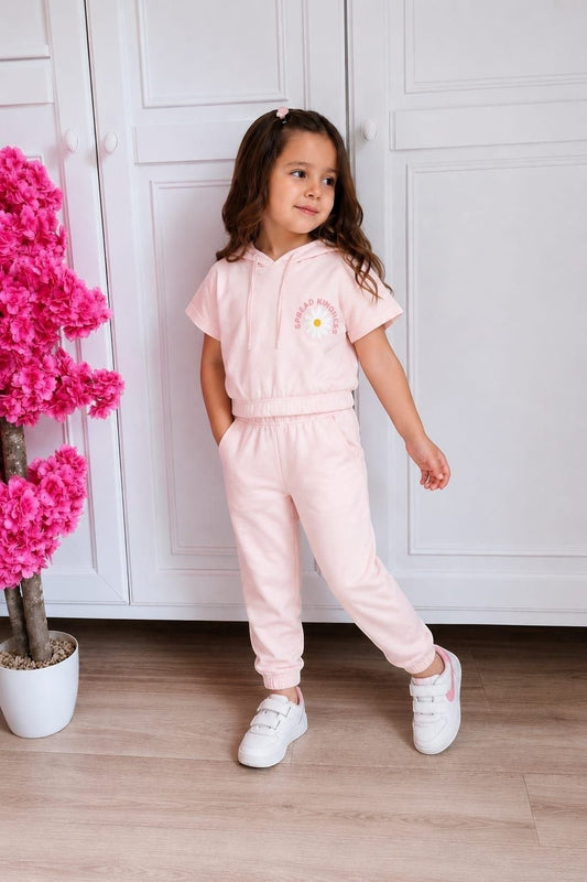 The Nile Luxuries light pink short-sleeve cropped hoodie and jogger set with a daisy graphic on a young girl.