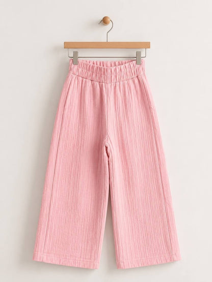 The Nile Luxuries pink wide-leg trousers in crinkled cotton muslin with a high-rise elasticated waistband.