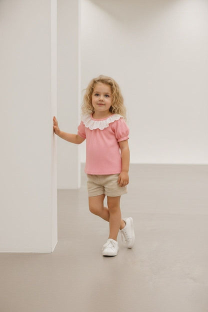 The Nile Luxuries pink ribbed knit puff sleeve top with white lace collar on a young girl.