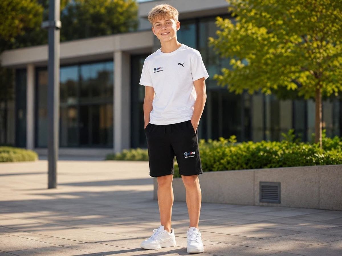 The Nile Luxuries PUMA BMW Motorsport set featuring a white crew-neck t-shirt and black athletic shorts on a young man.