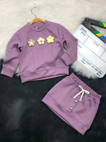 The Nile Luxuries girls purple sweatshirt and skirt set with three textured floral appliques and button details.