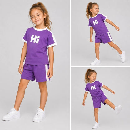 The Nile Luxuries purple kids t-shirt and shorts set with white Hi graphic and athletic side stripes on a young girl.