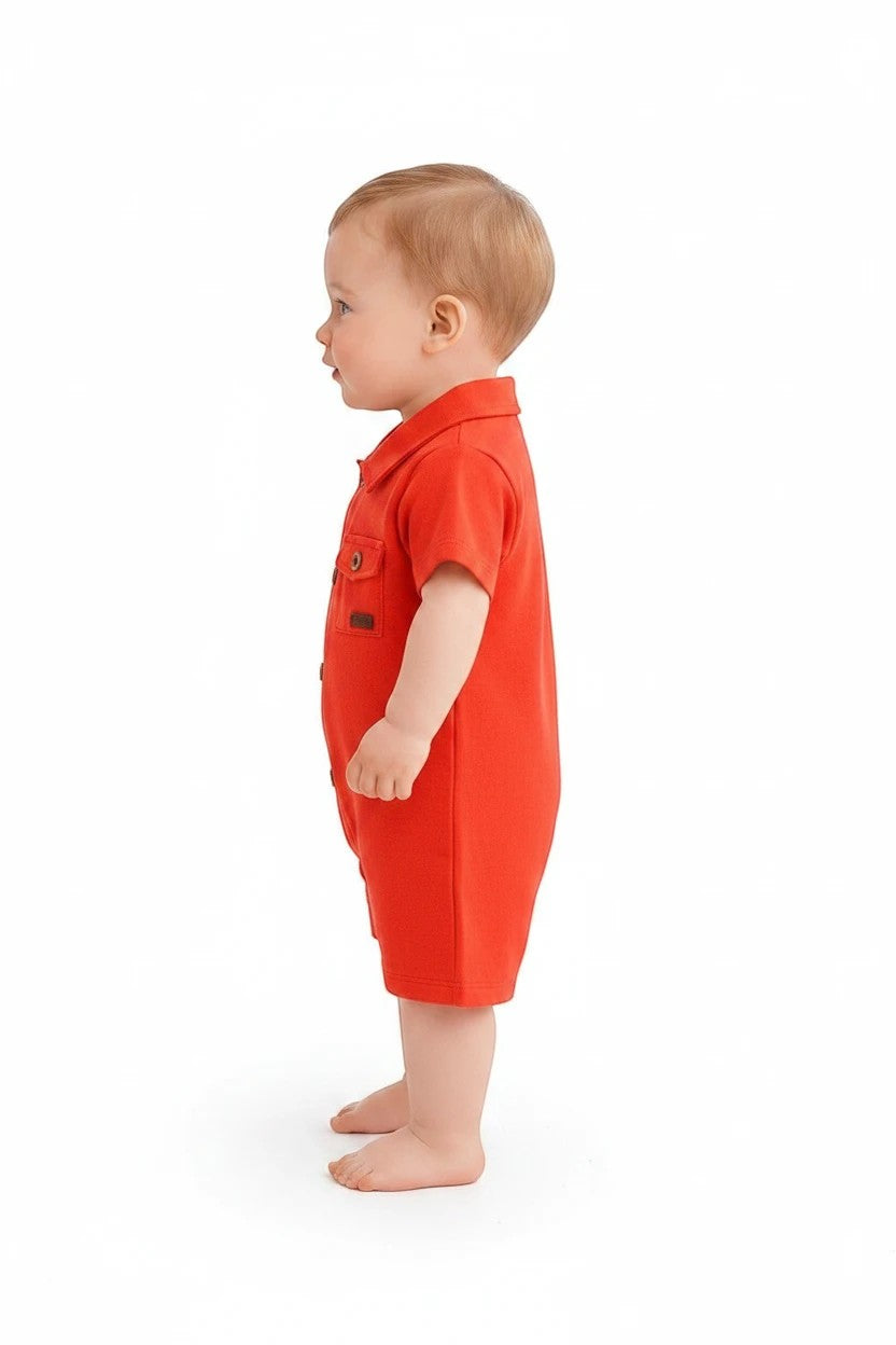 Baby wearing a red short-sleeve collared romper from The Nile Luxuries with button-down front and chest pockets.