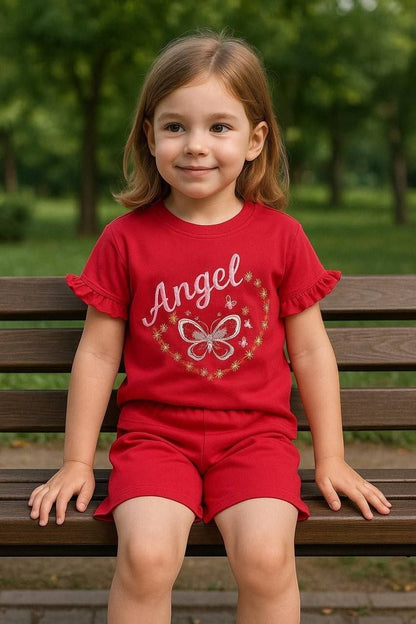 The Nile Luxuries red girls t-shirt and shorts set with ruffled sleeves and Angel butterfly graphic on a park bench.