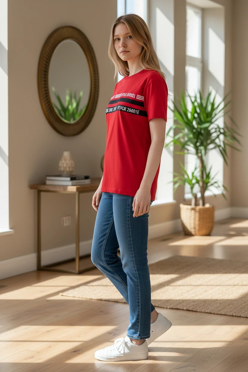 The Nile Luxuries red performance t-shirt with chest graphic print worn by a woman with blue jeans and white sneakers