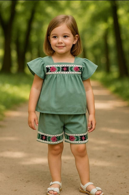 The Nile Luxuries toddler girl sage green flutter-sleeve top and shorts set with floral embroidery and lace trim.