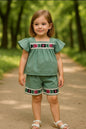 The Nile Luxuries toddler girl sage green flutter-sleeve top and shorts set with floral embroidery and lace trim.