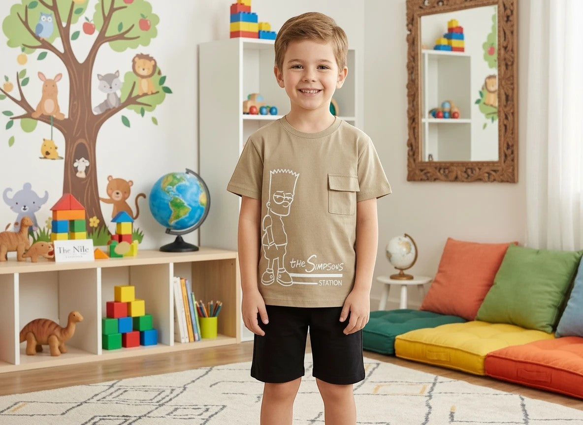 The Nile Luxuries tan Bart Simpson graphic t-shirt with chest pocket and black shorts on a smiling young boy.