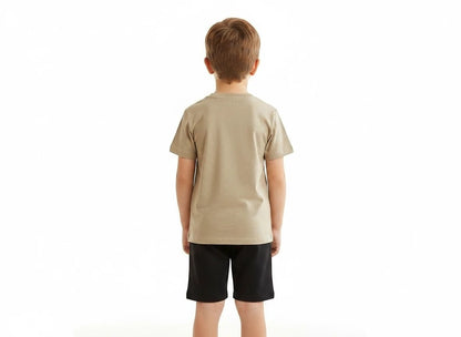 Back view of a boy wearing The Nile Luxuries tan crew-neck t-shirt and black shorts set on a white background.