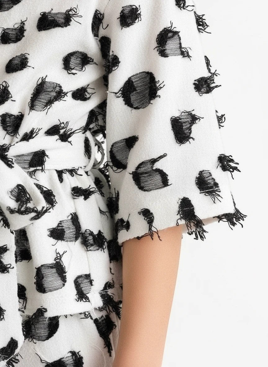 The Nile Luxuries girls white lounge set with black textured dot pattern, kimono sleeves, and frayed edge details.