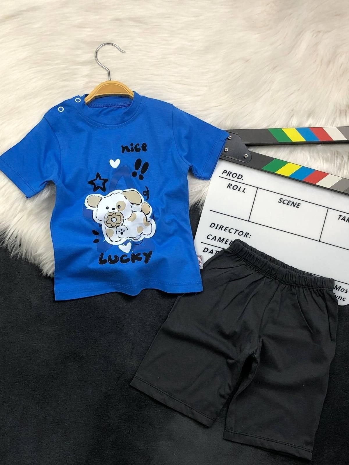 The Nile Luxuries toddler blue t-shirt with puppy graphic and black shorts set featuring shoulder snap buttons.