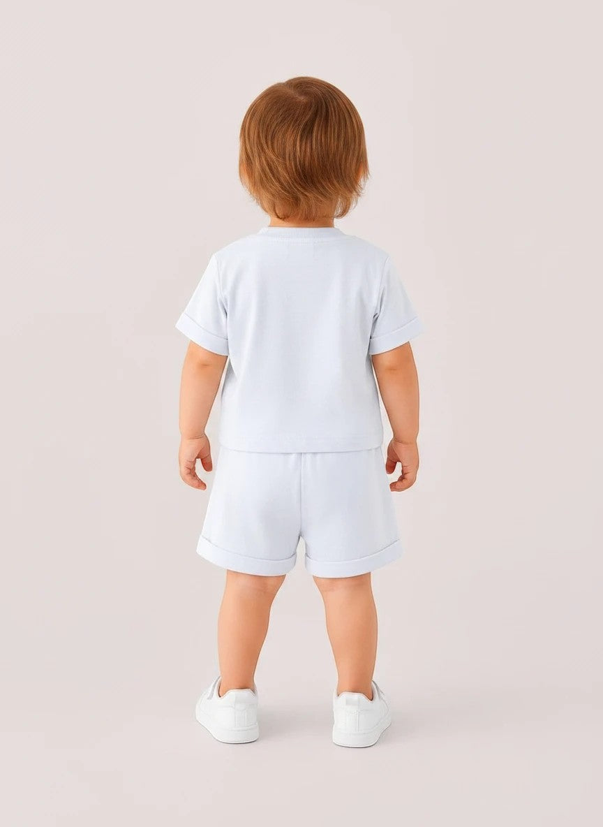 Toddler wearing The Nile Luxuries light blue short sleeve shirt and matching shorts from behind