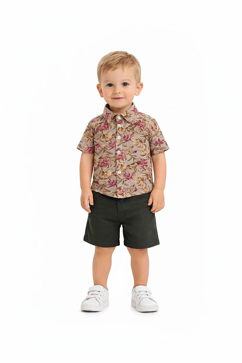 Toddler boy wearing The Nile Luxuries floral button-down shirt and olive green shorts with white sneakers