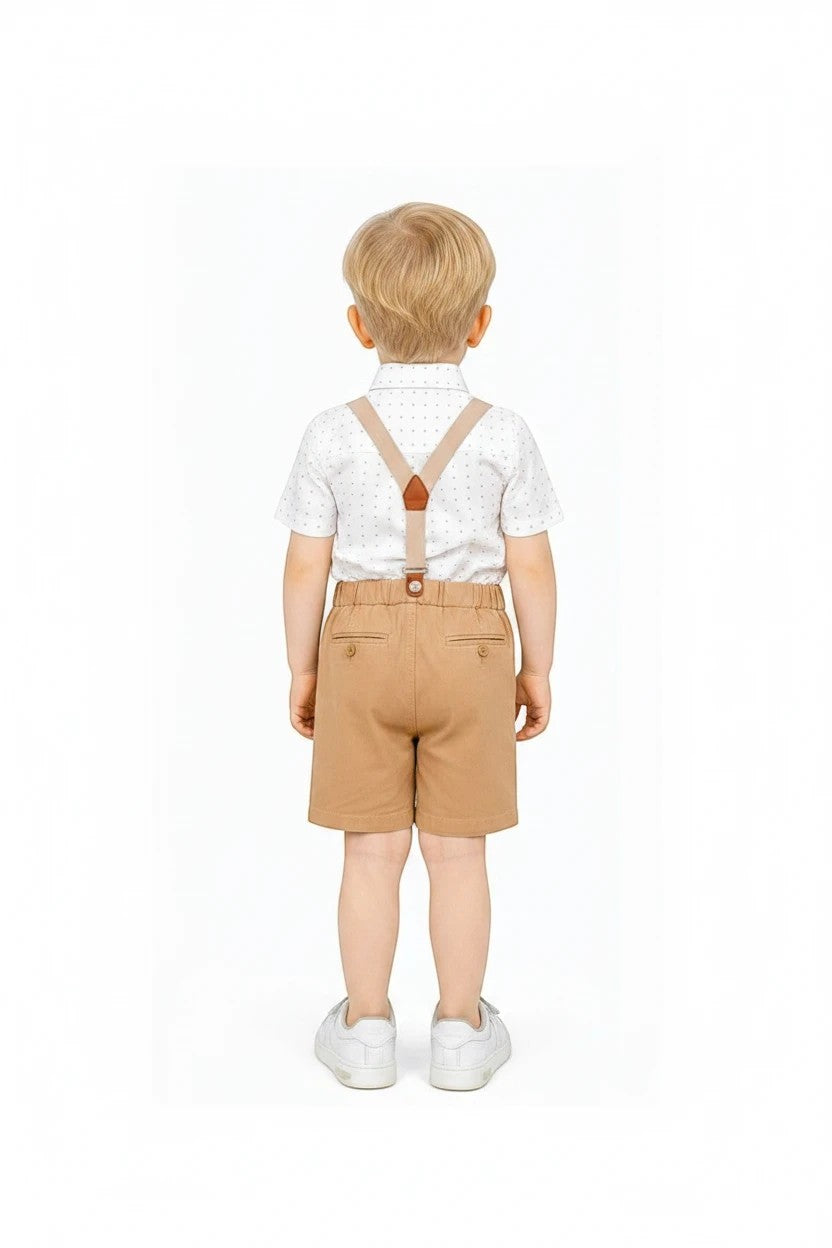 Toddler boy wearing The Nile Luxuries formal white patterned shirt, tan shorts, and suspenders from behind.