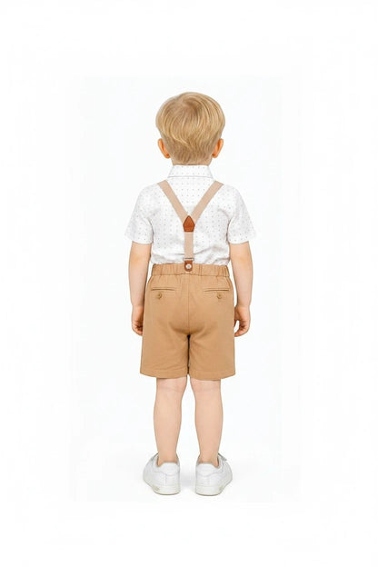 Toddler boy wearing The Nile Luxuries formal white patterned shirt, tan shorts, and suspenders from behind.