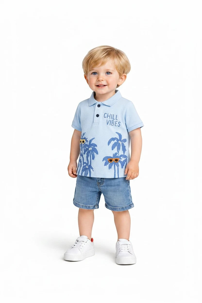 Toddler boy wearing The Nile Luxuries light blue tropical polo shirt with palm trees and denim shorts on white background
